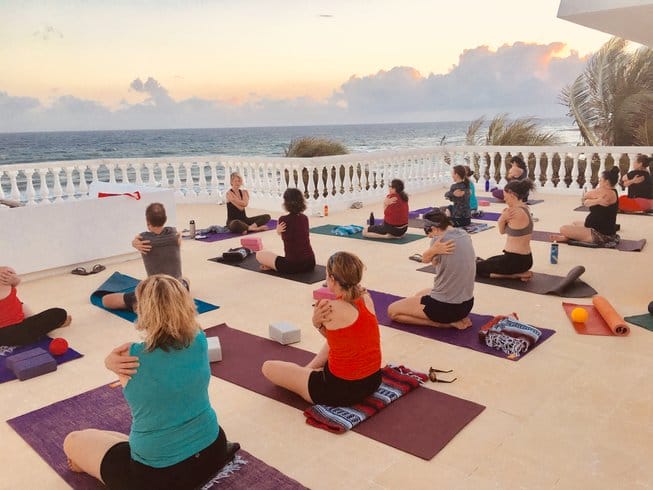 people doing yoga beach front 